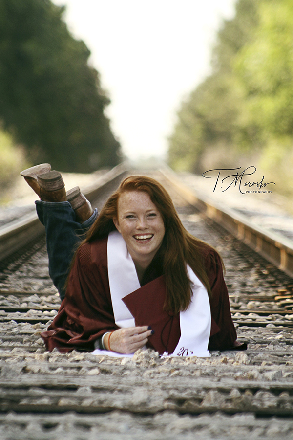 girl graduation on railroad track